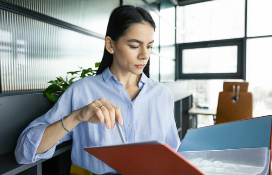 Business professional woman reading paper financial report. Reviewing contract. Woman reviewing document in office. Businesswoman checking data. Business success. Successful businesswoman assistant