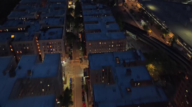 Nighttime aerial establishing shot over South Bronx revealing New York City, illuminated cityscape, buildings, streets and Manhattan skyline