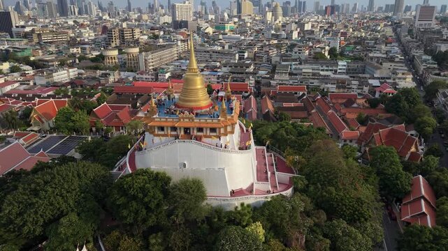 Bangkok, Thailand - 03 June 2026: Aerial view of Wat Saket Ratchawora Mahawihan temple with its golden stupa rising above the city rooftops and lush trees.