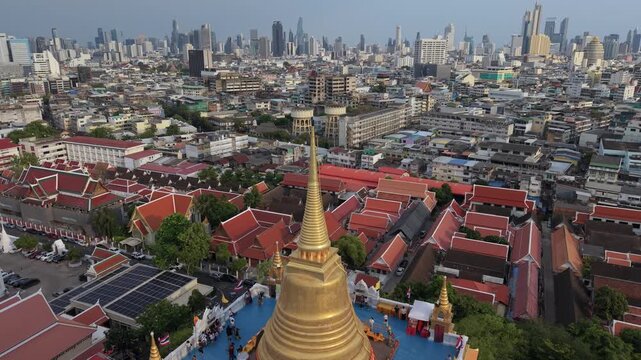 Bangkok, Thailand - 03 June 2026: Aerial view of Wat Saket Ratchawora Mahawihan temple complex with its golden chedi and red roofs against the city skyline in Bangkok, Thailand.
