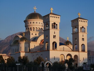 Obraz premium Orthodox Cathedral with Mountain Background at Sunset