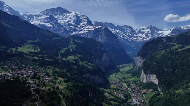 Aerial panorama of Lauterbrunnen Valley with alpine villages, cliffs and snowcapped peaks near Wengen in the Swiss Alps.