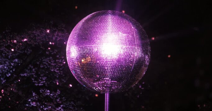 Sparkling, purple disco ball slowly rotating outside - zoomed in shot