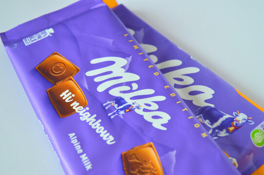 Two Milka chocolate bars in distinctive purple packaging placed on a white surface in a bright studio