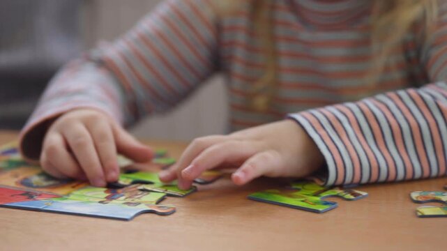 Young Child Solving Colorful Jigsaw Puzzle at Table