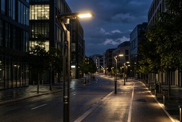 Obraz premium Modern streetlights illuminate an urban street at night