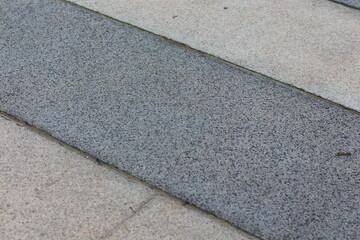 Fototapeta premium Close-up texture of contrasting grey and beige paving stones on a pathway