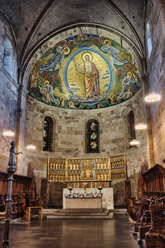 Lund, Sweden - 02 August 2025: View of Lund Cathedral interior featuring the golden apse mosaic of Christ in Majesty, the ornate altarpiece, and historic stone architecture.