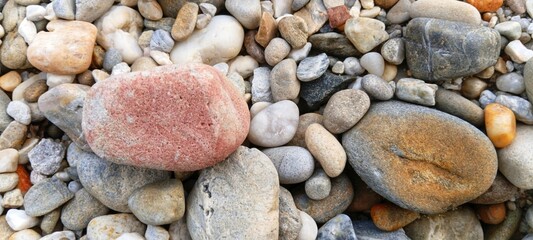 Smooth river stones creating a clean border around a sandy center, providing elegant copy space for summer travel advertisements © EfendyA