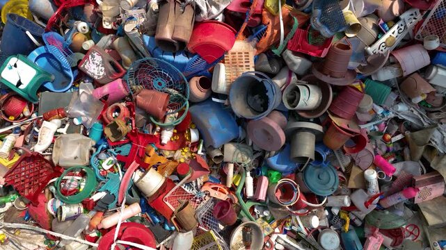 View of a massive pile of colorful plastic waste including bottles, crates, and household items at a recycling center in Bogura, Rajshahi Division, Bangladesh.