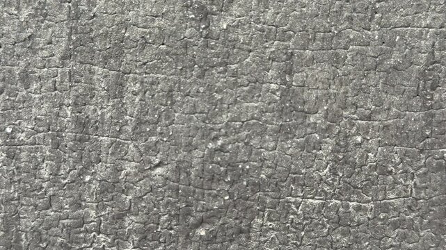Close-up textured Uniflex waterproofing membrane showing granular gray surface and seams, tight macro framing reveals mineral
