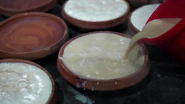 View of traditional Bogura Doi curd being prepared in terracotta clay pots with a creamy white texture in Bogura, Rajshahi Division, Bangladesh.