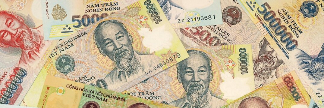 Vietnamese dong money bills in pile on table. Vietnam VND currency cash close up