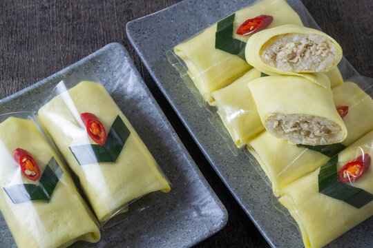 Traditional Javanese semar mendem, savory chicken stuffed sticky rice wrapped in thin egg omelet, Authentic Indonesian snack