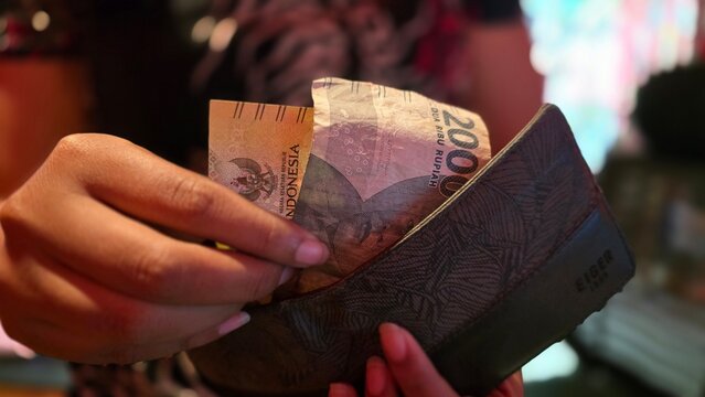 Hands Counting Indonesian Rupiah Banknotes from Wallet