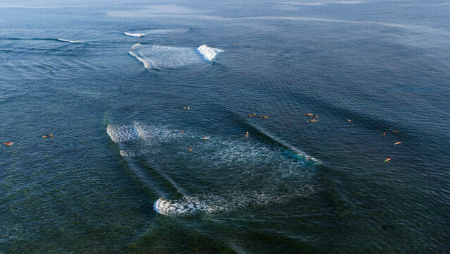 Aerial view of Cloud 9 Surfing Area with surfers waiting for waves in the deep blue ocean with white foam breaking General Luna, Caraga, Philippines.
