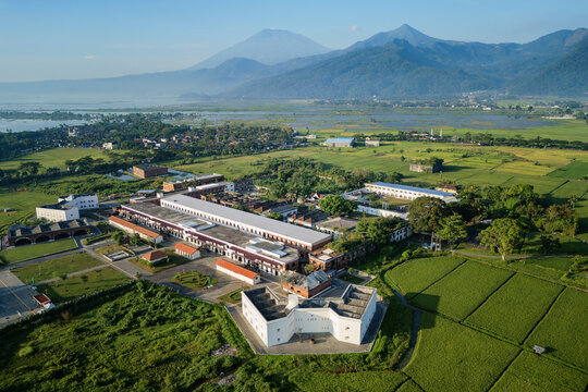 Aerial view of Benteng Fort Willem I surrounded by lush green rice fields and majestic mountains in Ambarawa, Central Java, Indonesia.