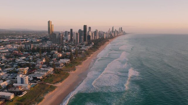Iconic Skyscrapers Along Sandy Coastline Of Main Beach At Sunrise In Gold Coast, Queensland. aerial pullback shot