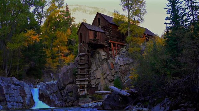 The Crystal Mill silver mining old rocky outcrop powerhouse wooden building Marble Colorado landmark fall autumn colors afternoon sunset blue sky landscape Crystal River falls bottom riverbed static