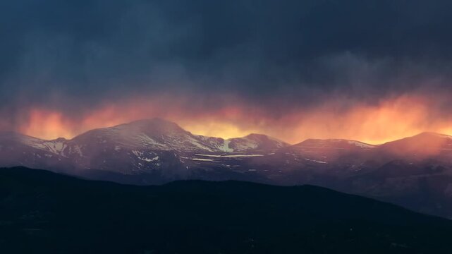 Sunset golden hour vibrant orange dark thunderstorm rain cloud fire orange sky Mount Blue Sky aerial drone Colorado Rocky Mountains SpringMount Evans Wilderness front range peaks landscape pan
