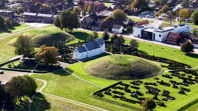 Aerial drone view of Jelling Church and ancient Viking burial mounds at UNESCO heritage site in Denmark