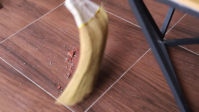 Video of sweeping up broken flower vases with a floor broom.