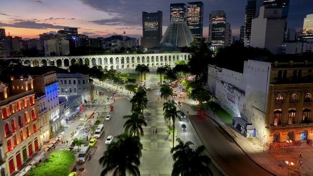 Sunset Skyline In Carioca Aqueduct In Rio De Janeiro In Brazil. Illuminated City Landscape. Downtown District. Landmark Bows Of Lapa. Sunset Skyline In Carioca Aqueduct In Rio De Janeiro In Brazil.