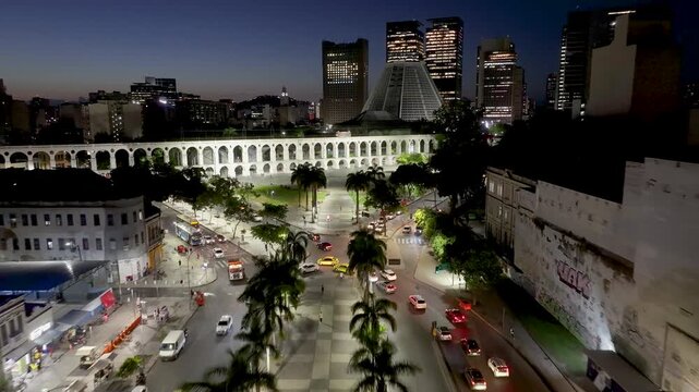 Lapa Bows At Night In Rio De Janeiro In Brazil. Illuminated City Landscape. Downtown District. Highrise Buildings. Lapa Bows At Night In Rio De Janeiro In Brazil. Railway Transport.