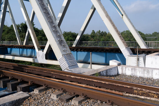 A close-up view of the structural steel framework and railway tracks of the historical Renville bridge in Kebumen, Central Java, Indonesia.