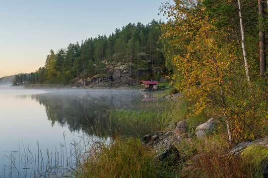 Wooden bathhouse and boat pier on the shore of Lake Ladoga near the village of Lumivaara on a foggy autumn morning, Ladoga Skerries, Lahdenpohya, Republic of Karelia, Russia