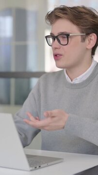 Young Man Talking on Video Chaton Laptop in Modern Office, Vertical Video
