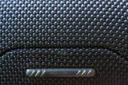 Close up view showcasing vehicle interior detail with black plastic grid pattern texture on compartment, evoking sleek modern feeling of calm professionalism with durable material design