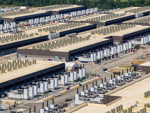 Aerial view of the data center buildings, large AI center structure surrounded by cooling and power systems