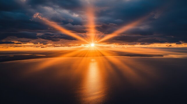 Golden sunbeams pierce through stormy clouds over tranquil water.