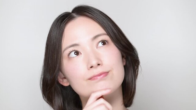 美容やセルフケアをどうしようか迷う、考え事をする若い女性の動画