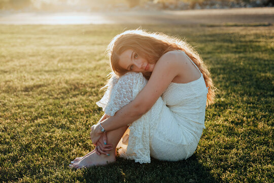 young woman curled up in the grass