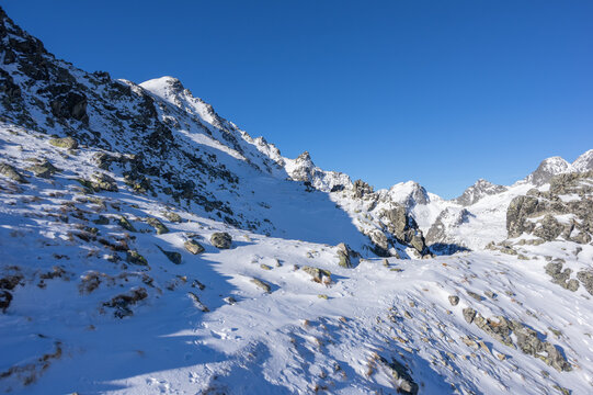View of the snow-covered Slavkovsky nos peak and rugged mountain ridges under a clear blue sky in the High Tatras Vysoke Tatry, Presov Region, Slovakia.