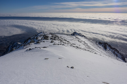 View of the snow-covered Slavkovsky nos peak overlooking a sea of clouds during a temperature inversion in Vysoke Tatry, Presov Region, Slovakia.