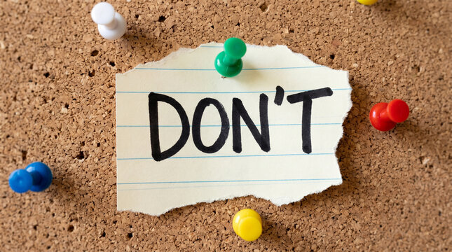 Don't word on torn paper pinned to corkboard, note with thumbtacks, important message for reminders and important to do lists.