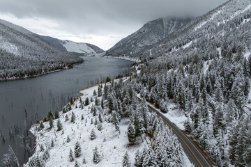Aerial photography of the natural landscape driving through the snowy forests of Montana, USA