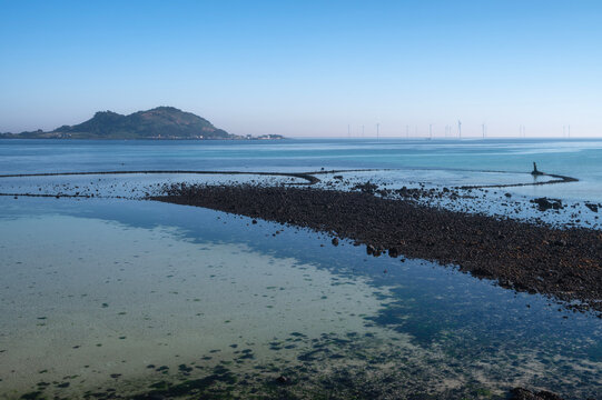 Volcanic Rock Fish Trap with Offshore Wind Turbines at Geumneung Beach Sunset Seascape, Jeju Island, South Korea
