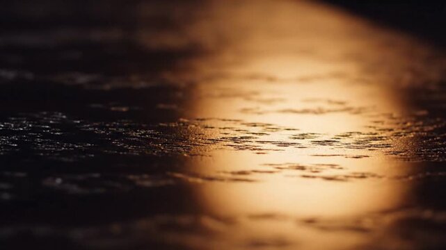 Warm golden light beam illuminating dark textured wooden surface with subtle grain patterns