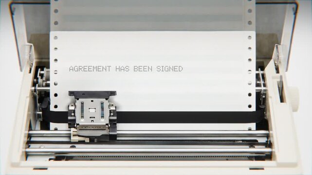 Old Dot Matrix Printer Printing AGREEMENT HAS BEEN SIGNED Text on continuous white paper Close Up view.