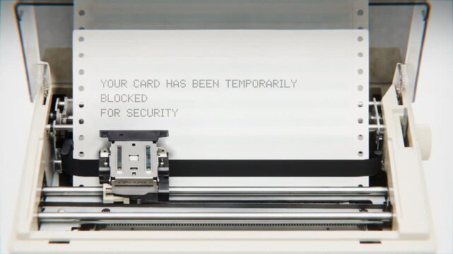 Old Dot Matrix Printer Printing YOUR CARD HAS BEEN TEMPORARILY BLOCKED FOR SECURITY Text on continuous white paper Close Up view.