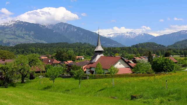 Scenic swiss village landscape with church and mountains