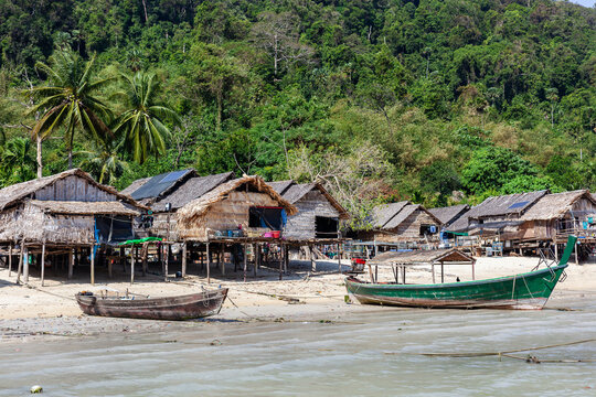 Moken Sea Gypsy Village. Traditional huts on Koh Surin, Thailand. Tropical coastal setting with boats.