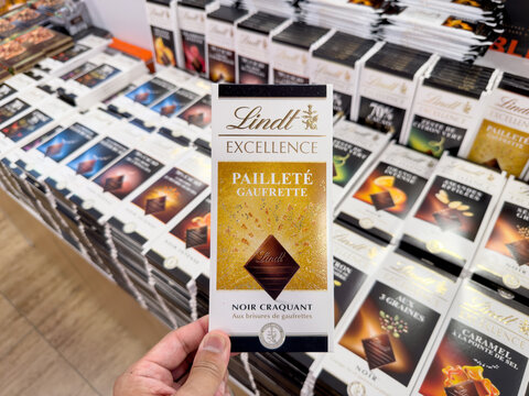 LANGKAWI, MALAYSIA - MAR 18, 2026: Close up of a person holding Lindt Excellence Paillet&eacute; Gaufrette dark chocolate bar in a retail store.
