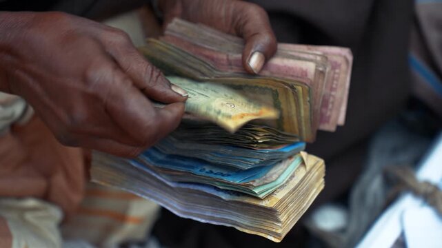 Bogura, Bangladesh - 02 June 2026: View of hands counting a large stack of worn Bangladeshi Taka banknotes during a transaction.