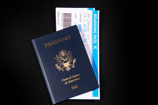 US passport with boarding passes on black. Boarding and airport check in. American passport cover with airline tickets. Passport and boarding pass. Passport and flight documents.