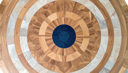 Naklejka premium Close-up of a circular wooden floor pattern, alternating colors and materials, radiating from a dark center